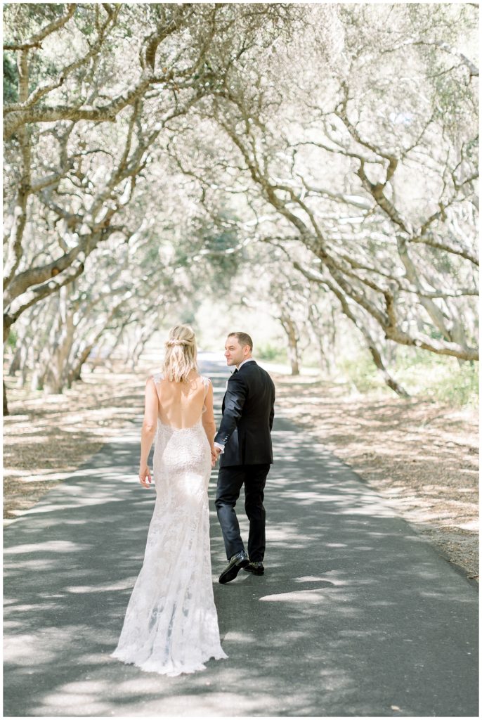 Bride and groom walking through oak tree canopy at Tehama Golf Club