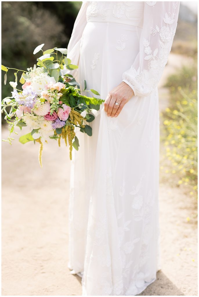 bride holding her bouquet in her BHLDN gown from the shoulders down at her Carmel elopement on the beach