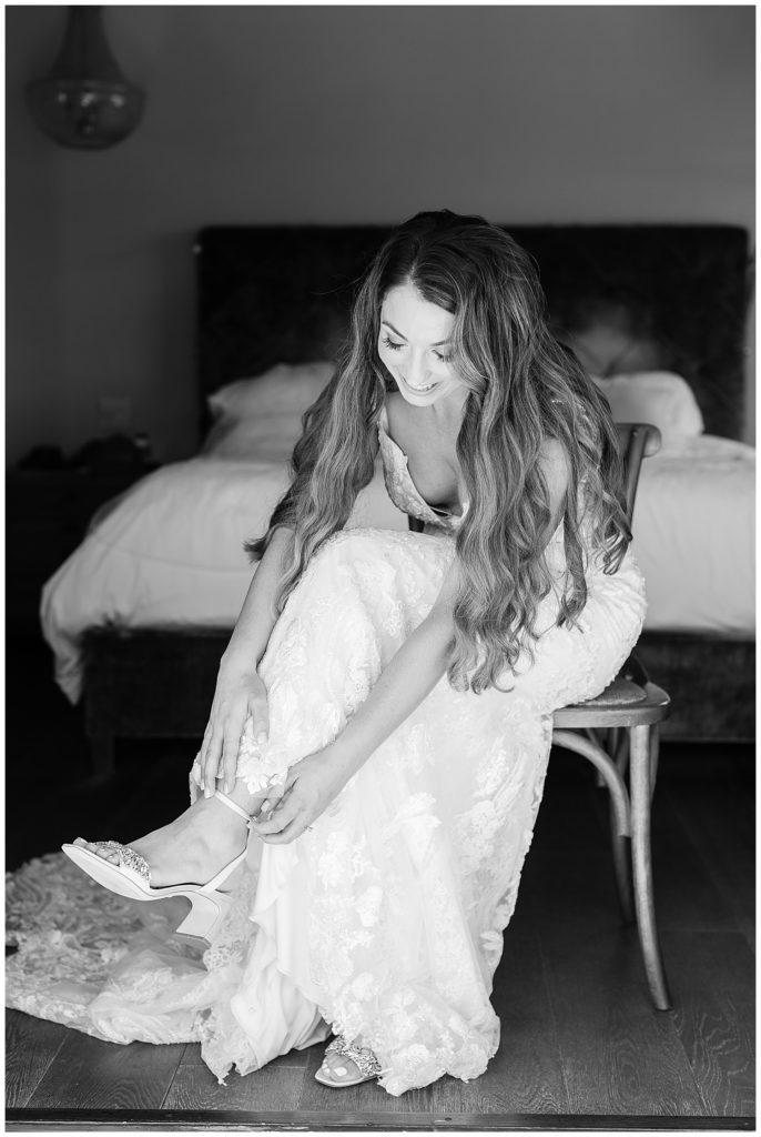 black and white portrait of the bride putting on her shoes for her Big Sur adventure elopement by film photographer AGS Photo Art