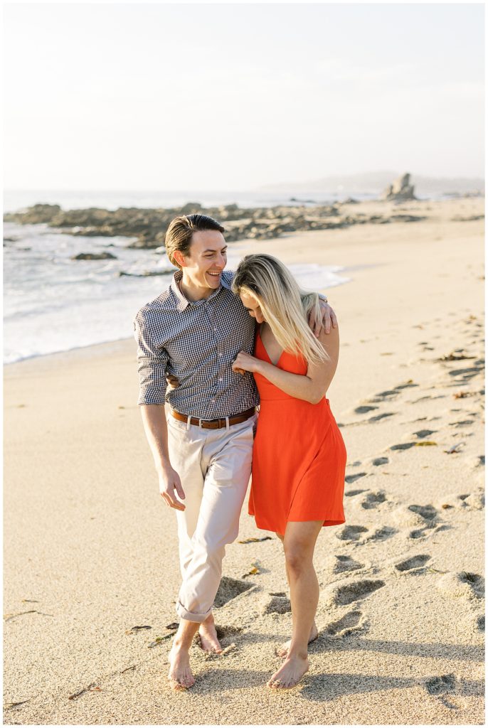 a couple walking down the beach during Carmel surprise proposal