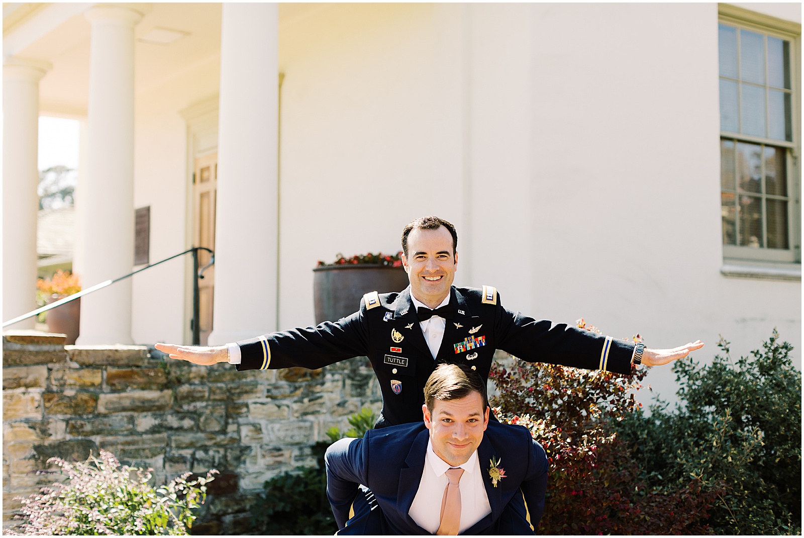 portrait of the groom getting a piggyback ride from a groomsmen