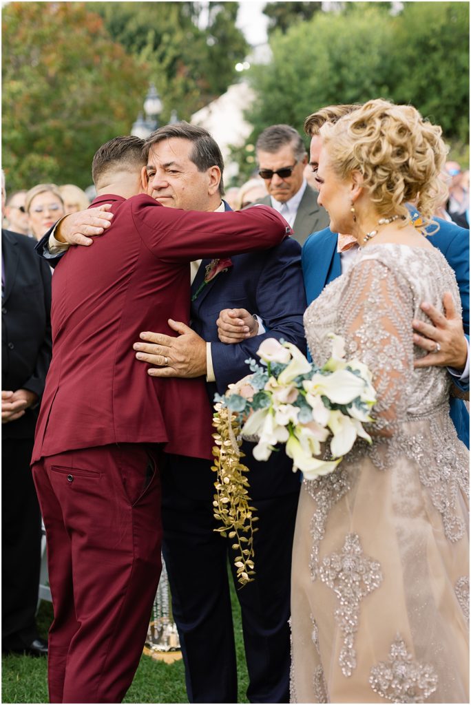portrait of groom hugging father during ceremony by film photographer AGS Photo Art