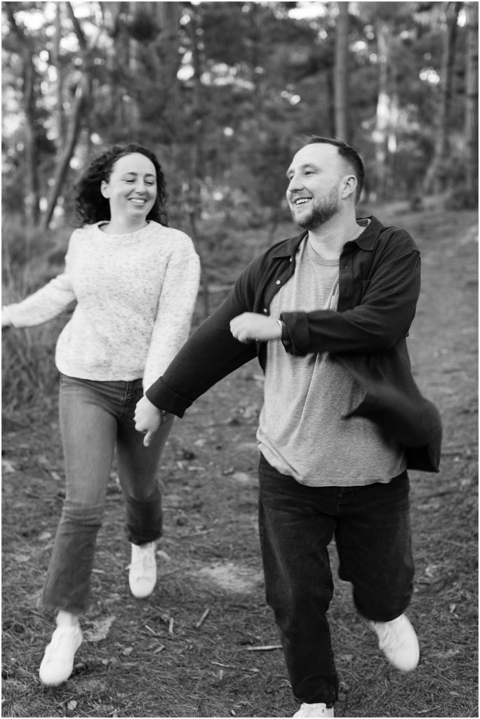 portrait of couple running through forest together by film photographer AGS Photo Art