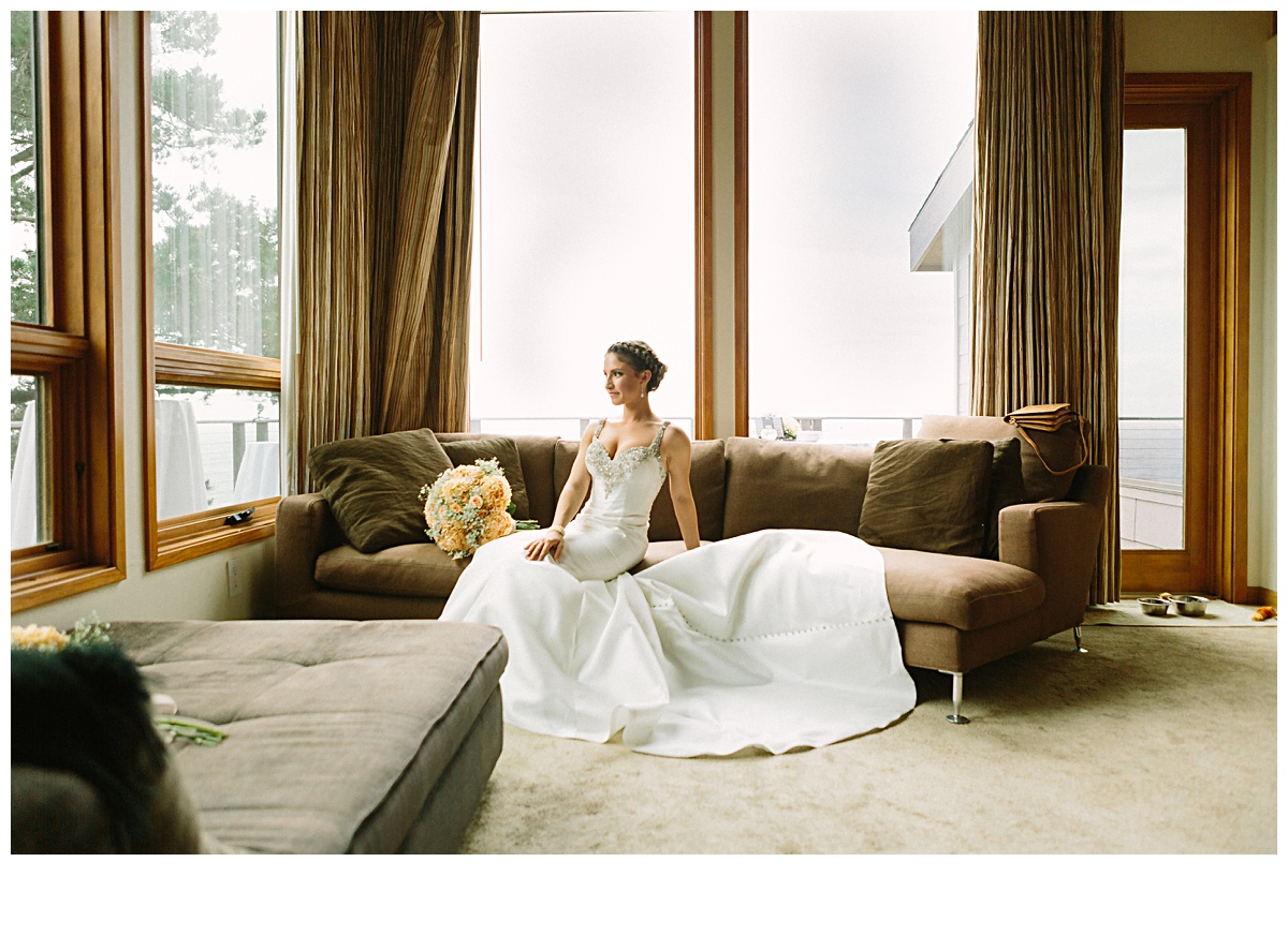 iconic bridal portrait in Big Sur California sitting on couch looking into the pacific ocean