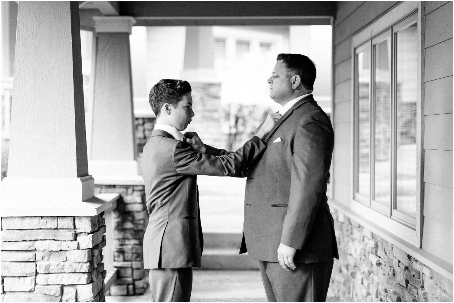 groom with new son tying each others tie black and white image