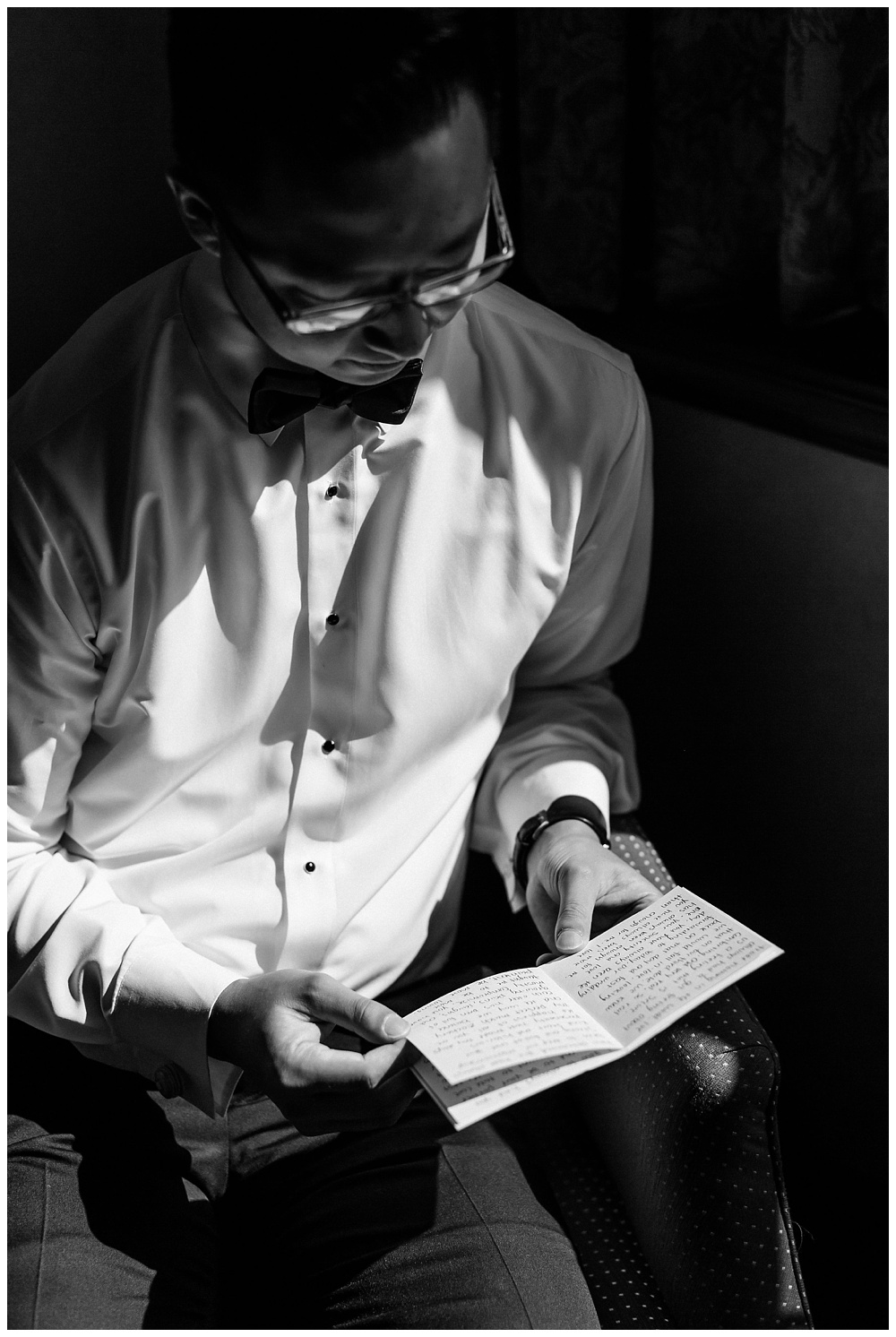 A black and white portrait of groom reading his vows on wedding day at the Pomme