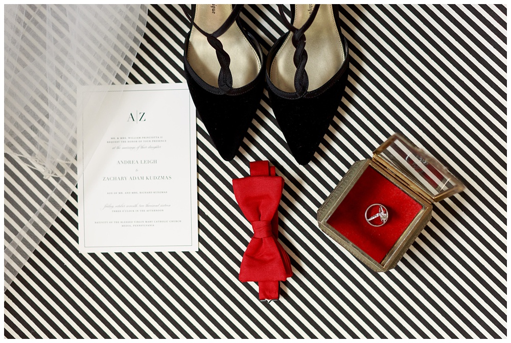 Black shoes, red bowtie and white invitations on wedding day at the Pomme in Radnor, PA