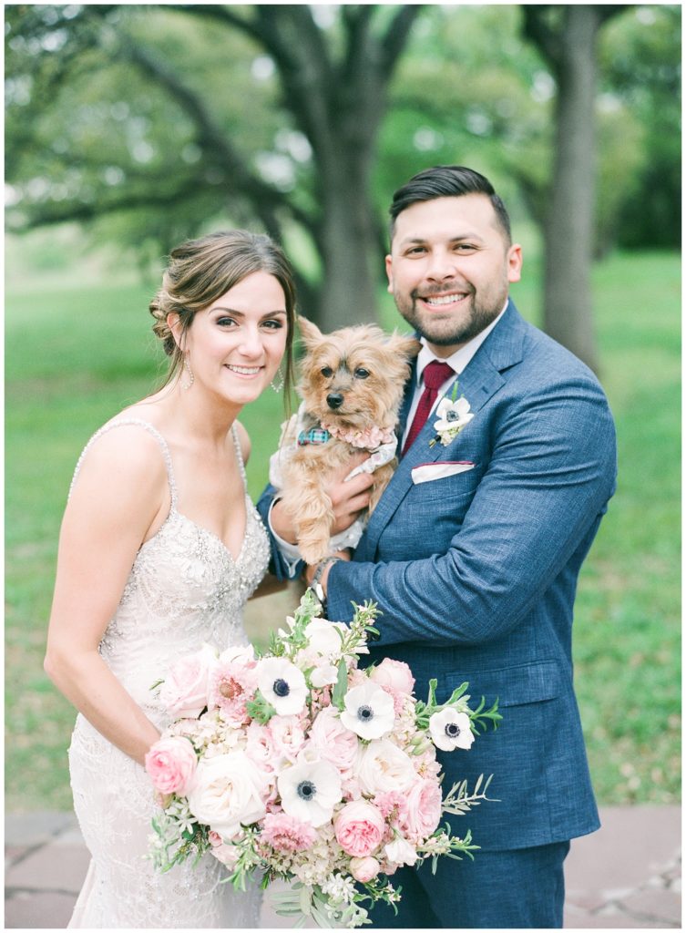 Bride and groom portrait with dog and pink and white bouquet