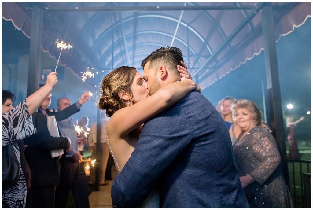 Bride and groom kiss after sparkler exit on wedding day in Austin