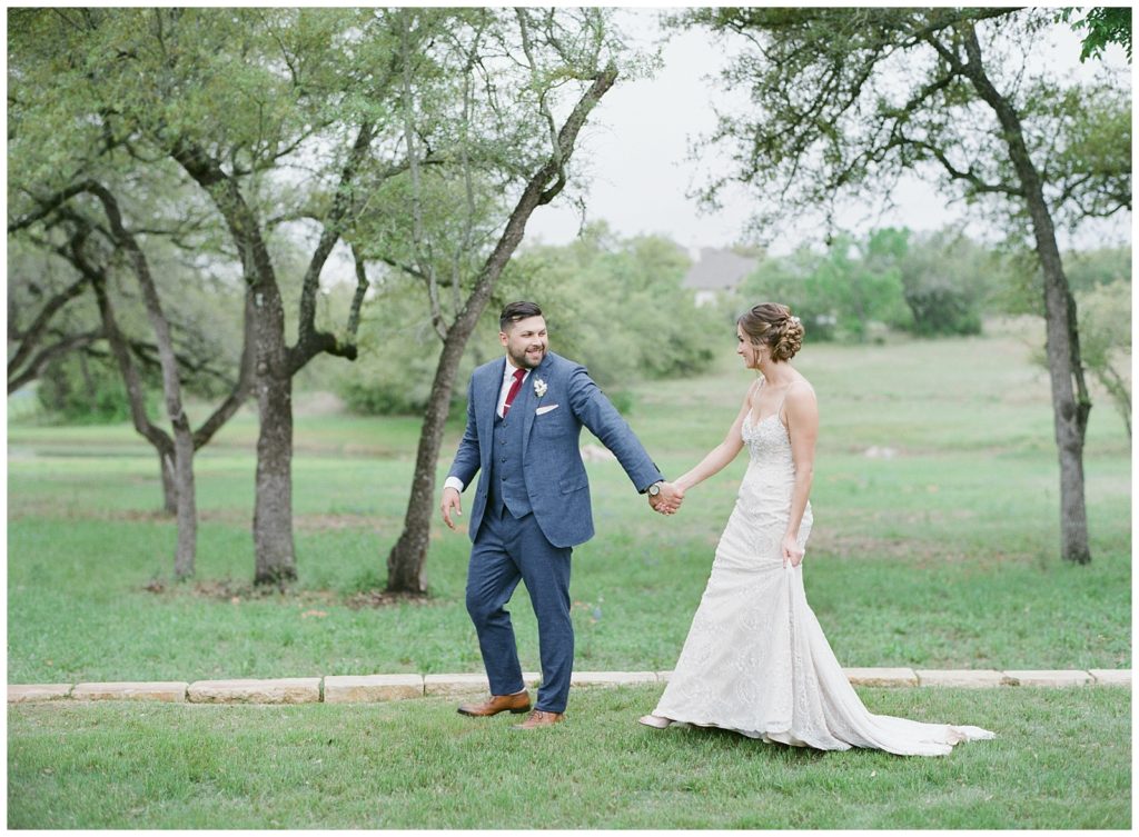 Bride and groom walking through lush greenery at the Ma Maison in Texas