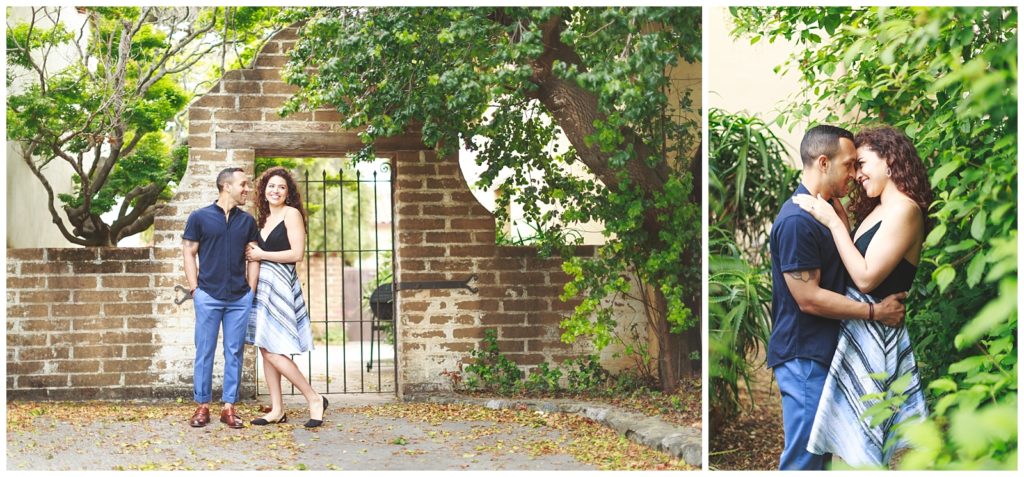 couple portaits in front of a gated brick wall with overhanging plants
