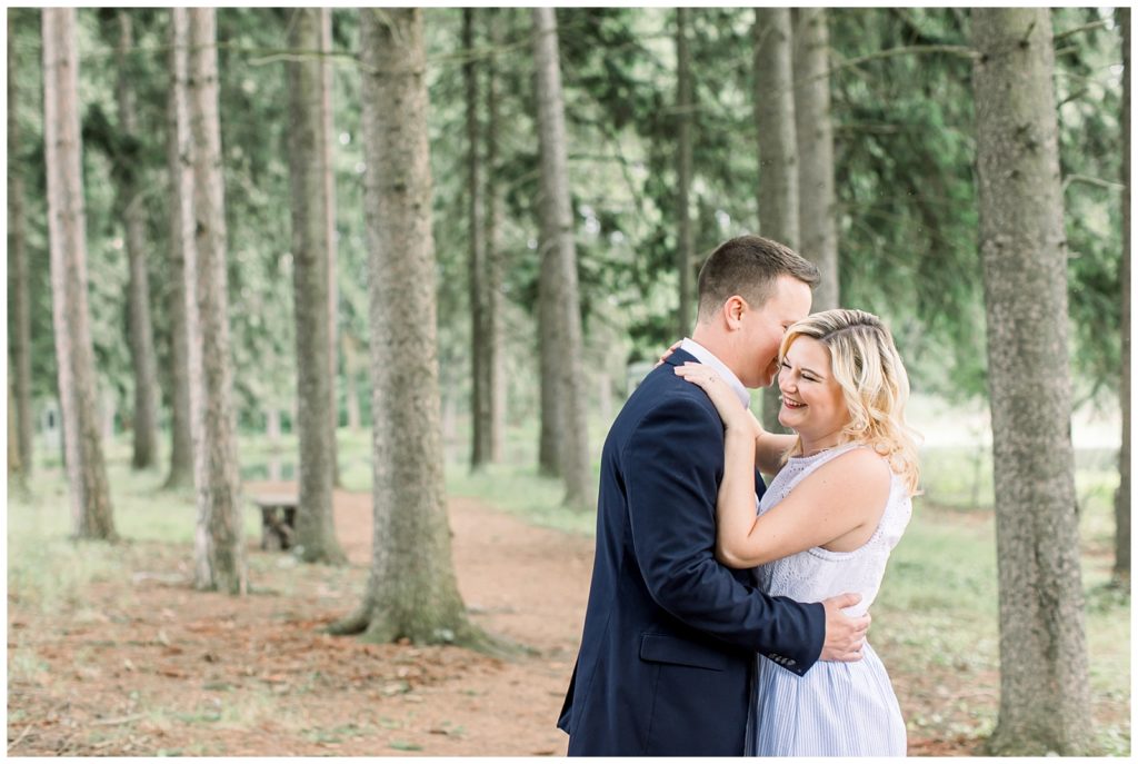 couple in each other's arms surrounded by trees