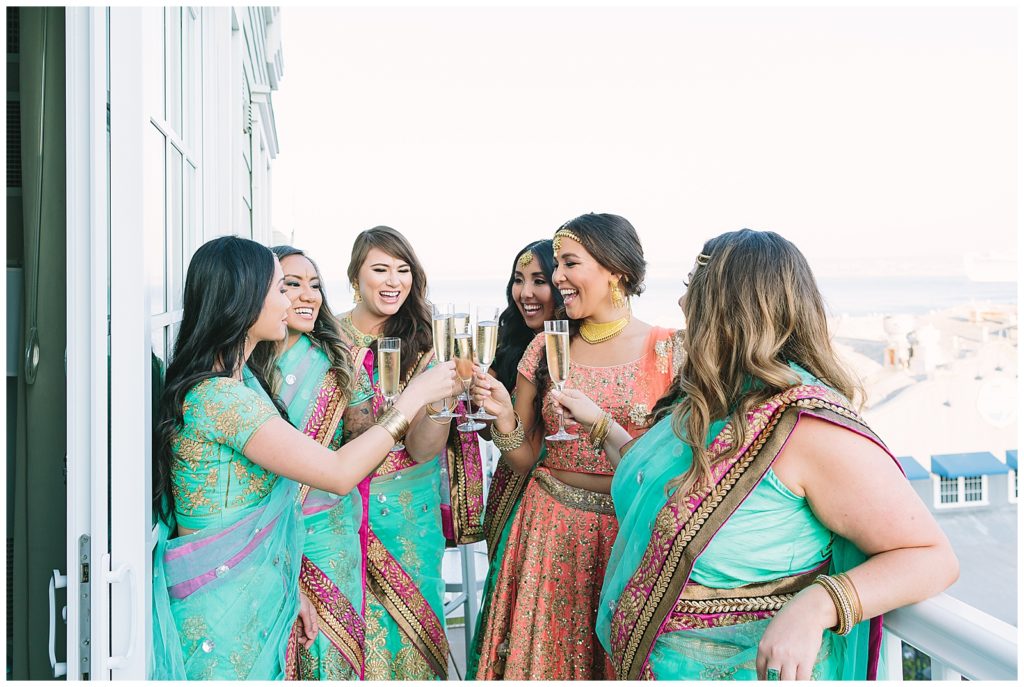 sangeet girls toasting and celebrating on hotel balcony colorful dresses