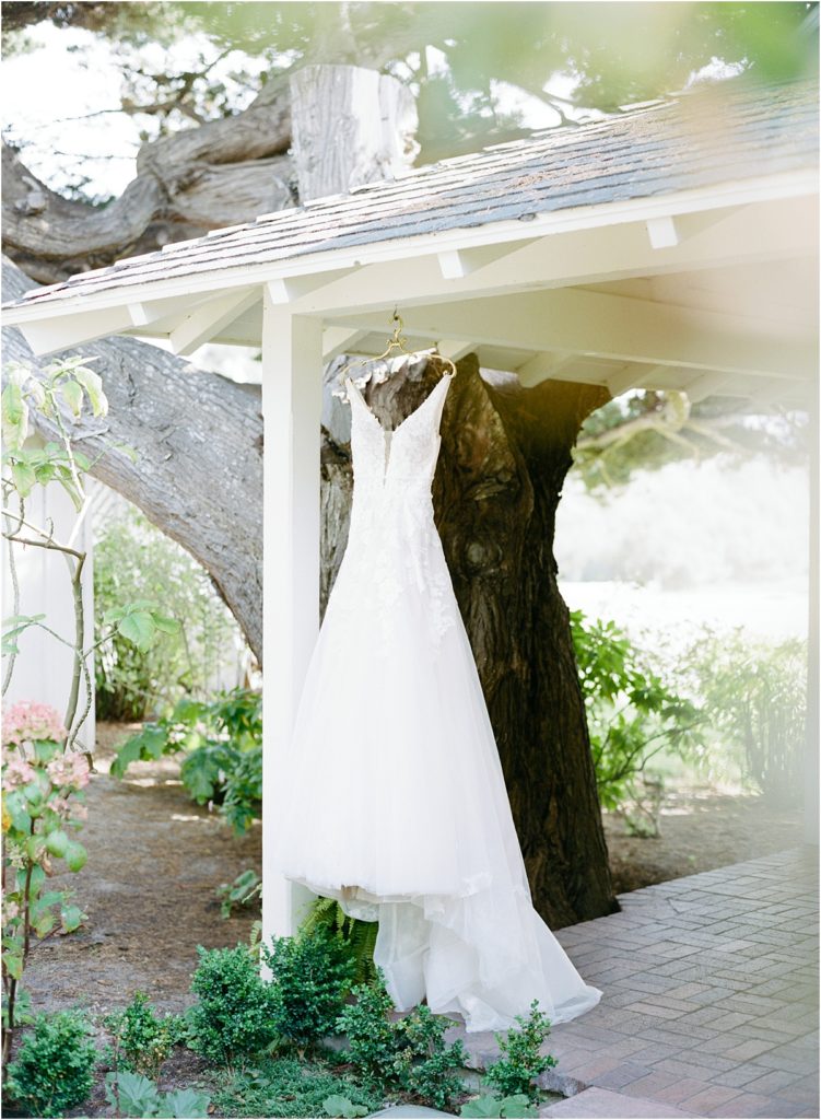 film image of haley paige gown hanging on porch with gold hanger from Anthropologie