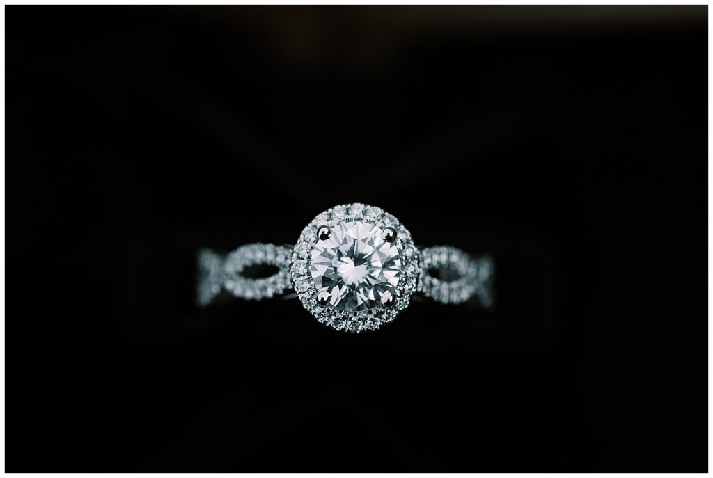 Beautiful And Whimsical Monterey Surprise Proposal close up photo of a round cut engagement ring with a halo setting and a braided band by film photographer AGS Photo Art
