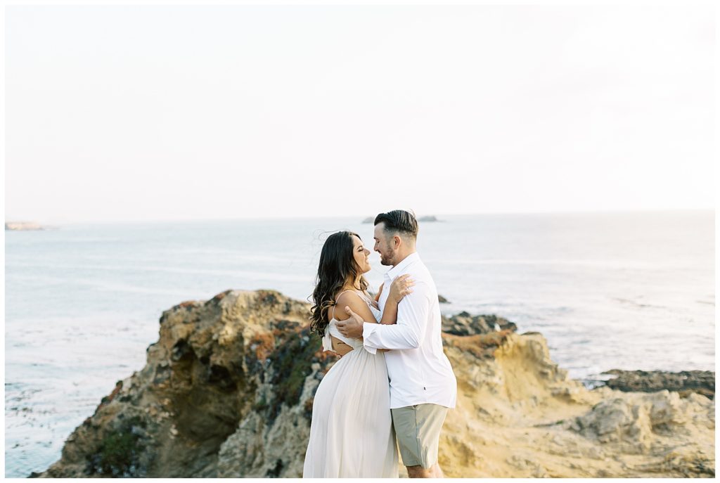 The couple in each other's arms, staring lovingly in celebration of their engagement In beautiful Big Sur, CA by film photographer AGS Photo Art