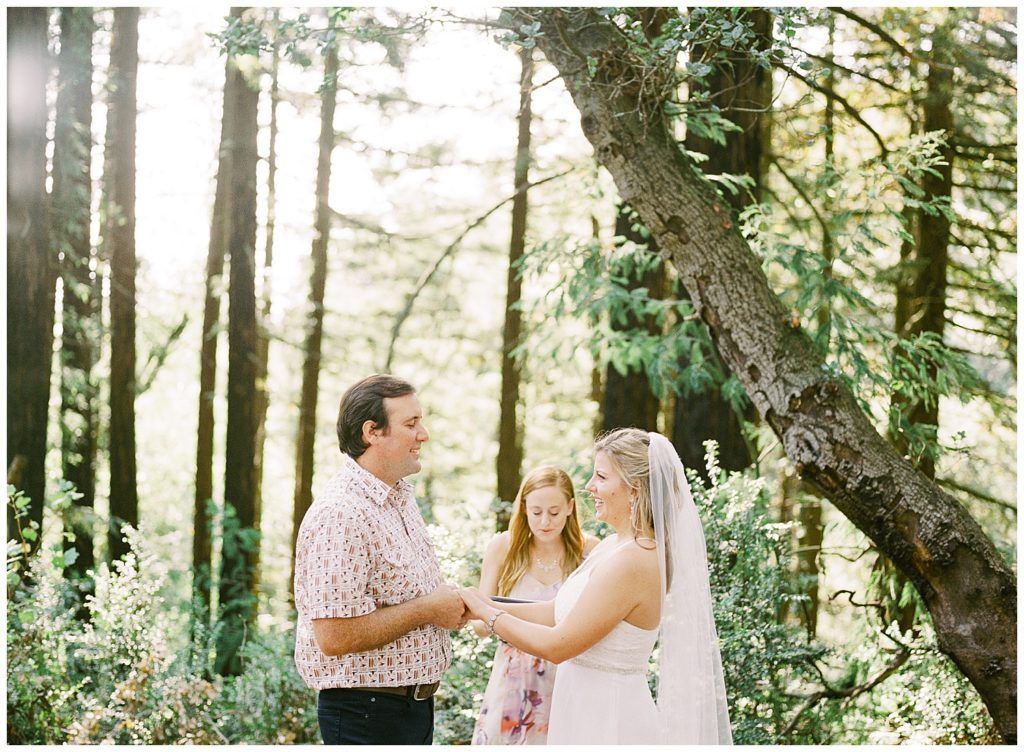 The bridge and groom, and their officiant in rustic woodland trails of Joaquin Miller Park by film photographer AGS Photo Art