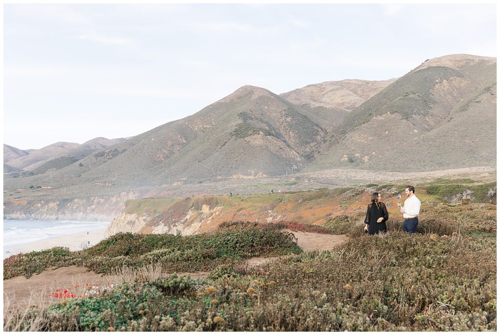 Big Sur landscape photograph full of mountains and cliffs; the couple reaching the surprise proposal spot