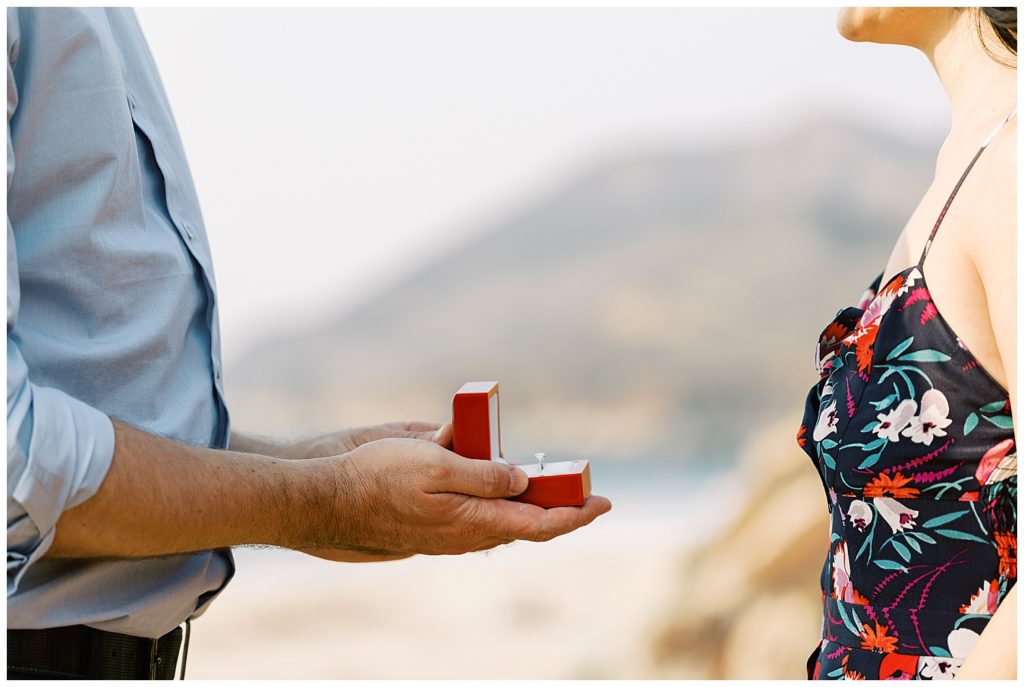 man presenting a red open ring box to his fiancée by film photographer AGS Photo Art