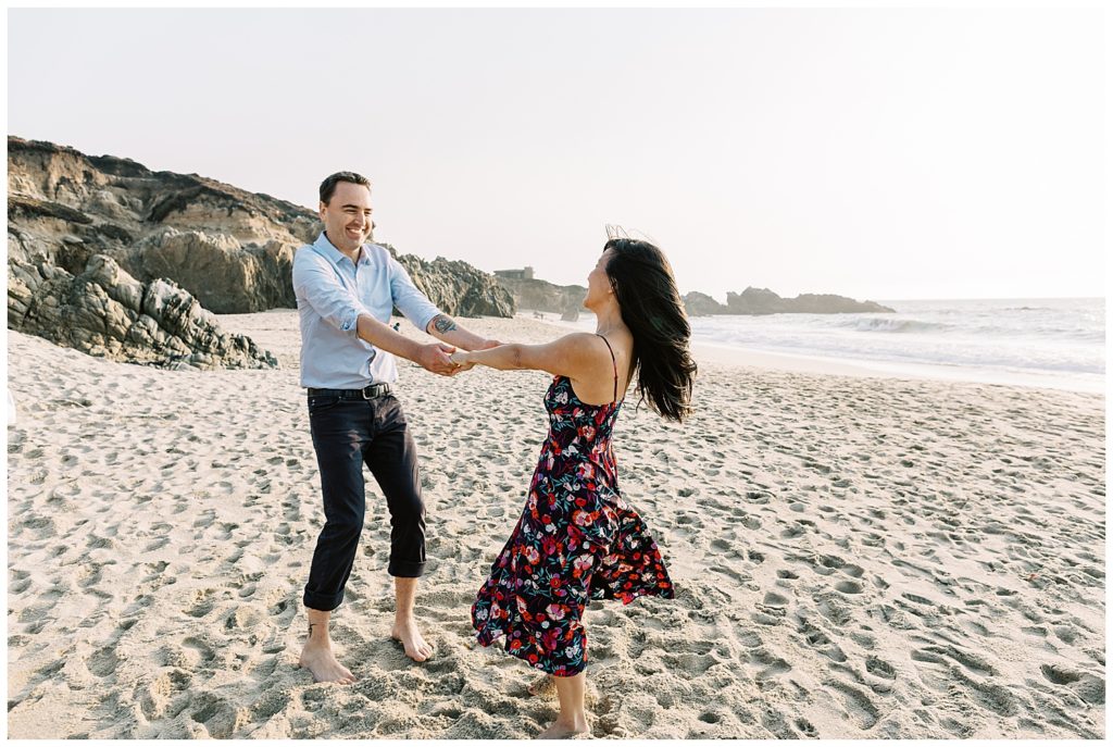couple dancing happily hand in hand on sand together