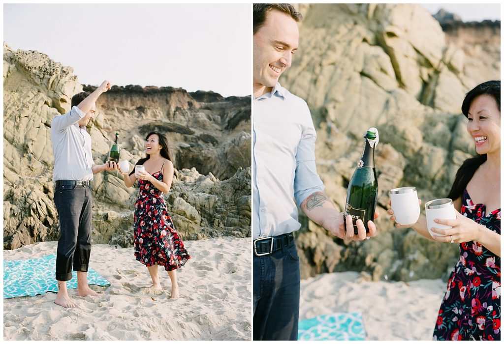 couple celebrating their Big Sur, CA surprise proposal with champang on the sand