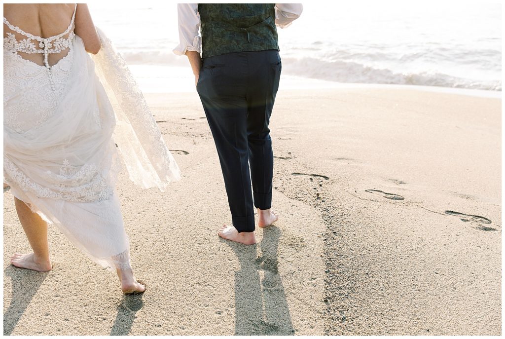 the couple walking barefoot in the sand at Pebble Beach during their private elopement by film photographer AGS Photo Art