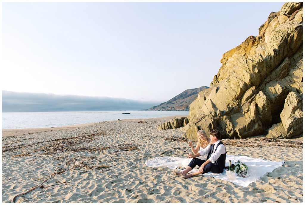 bride and groom enjoying their picnic on the sand at Pebble Beach by film photographer AGS Photo Art