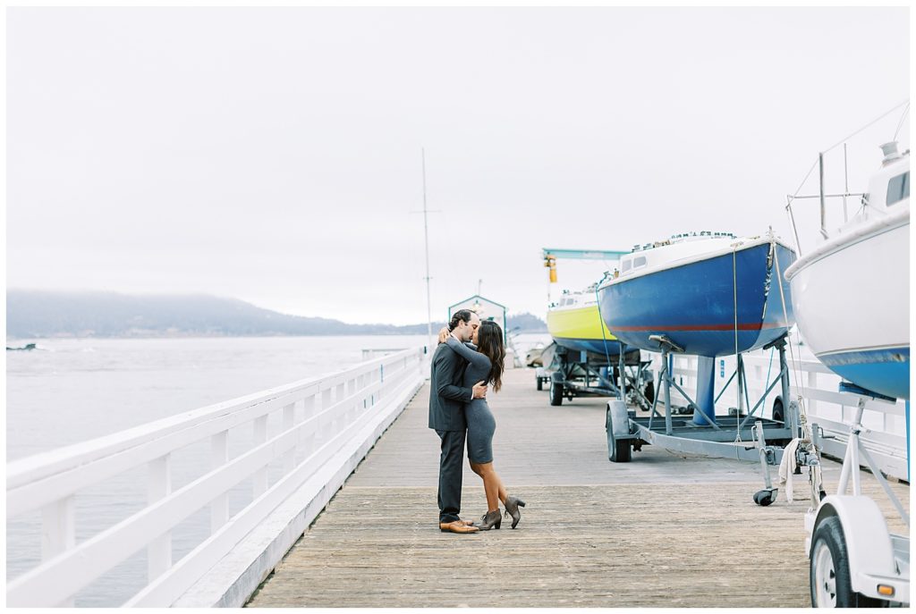 Couple sharing a kiss during their Surprise Proposal at Pebble Beach On The Docks by film photographer AGS Photo Art