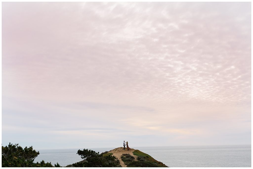 cotton candy pink and blue skies overhead the couple on a cliff in Big Sur for their sunset engagement shoot by film photographer AGS Photo Art