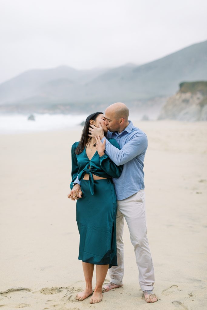 couple sharing a kiss on the sand at Garrapata Beach