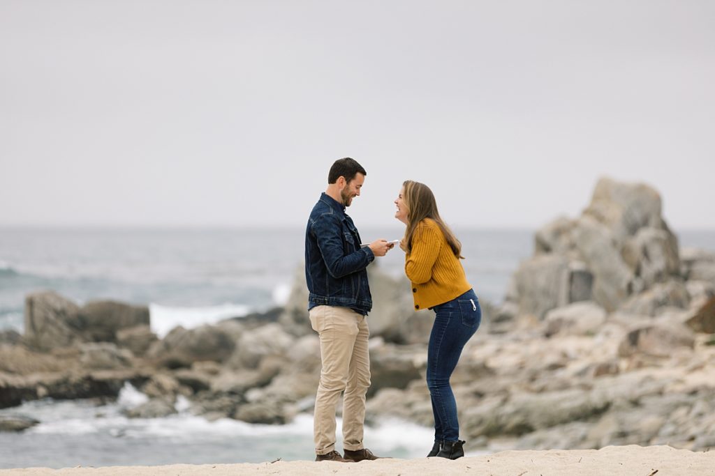 man reading his weekend itinerary to his fiancée detailing the celebration of his Carmel by the Sea surprise proposal to her