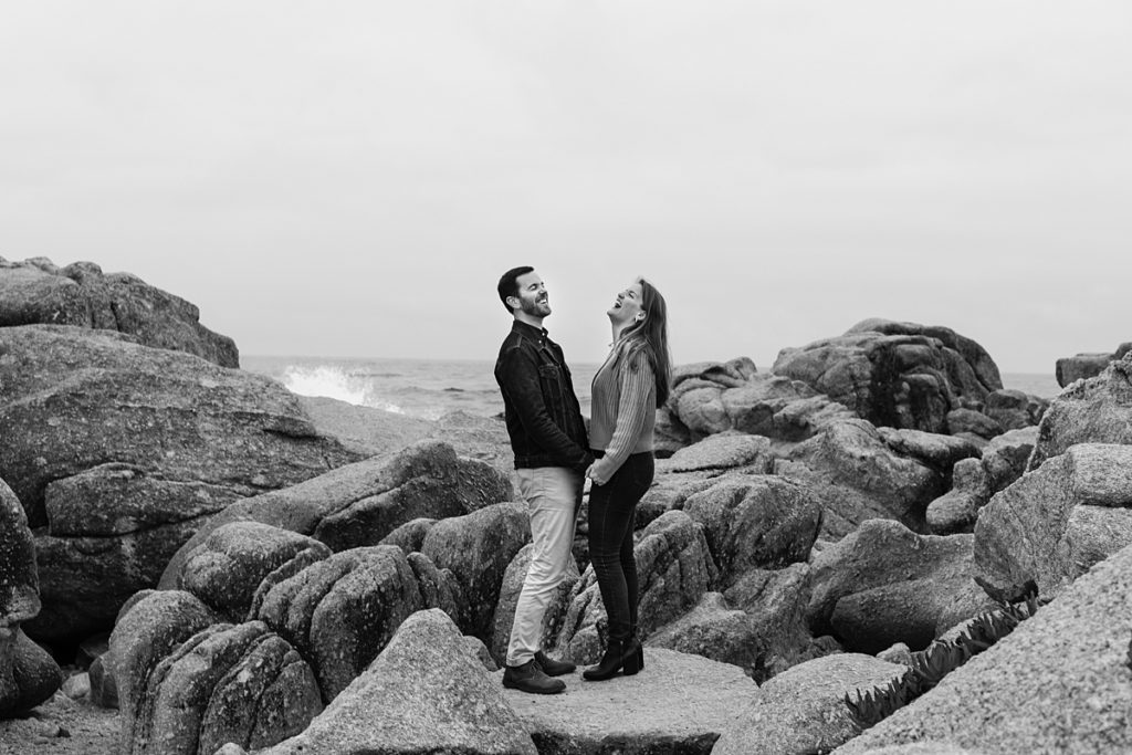 black and white Carmel Beach proposal portrait on the rocky cliffs