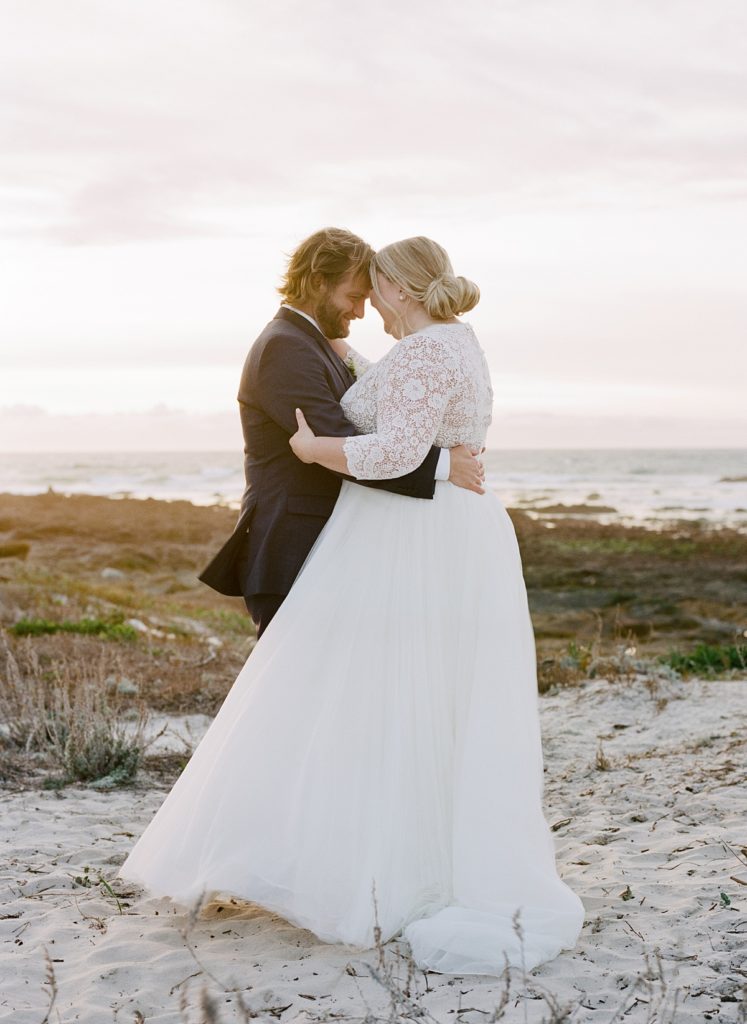 sunset couple portrait of the bride and groom embracing each other at Pebble Beach by film photographer AGS Photo Art