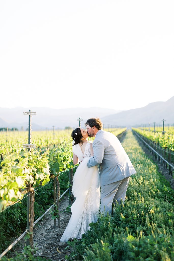portrait of the bride and groom sharing a kiss in the vineyards at Franscioni-Griva Corporation