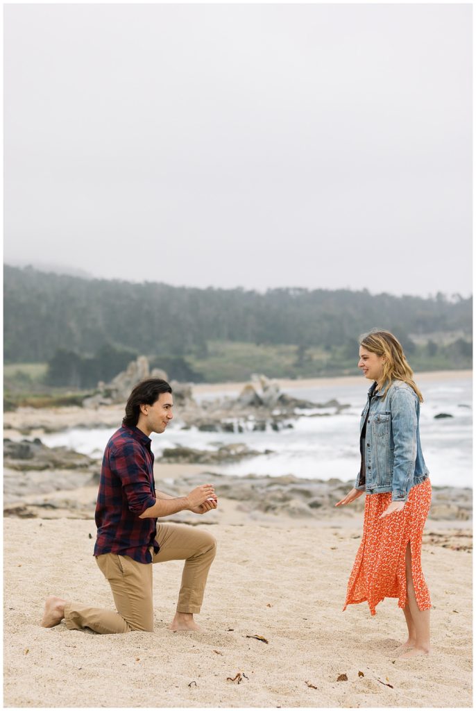 surprise proposal at Carmel by the Sea; man on one knee in the sand proposing to his partner by film photographer AGS Photo Art