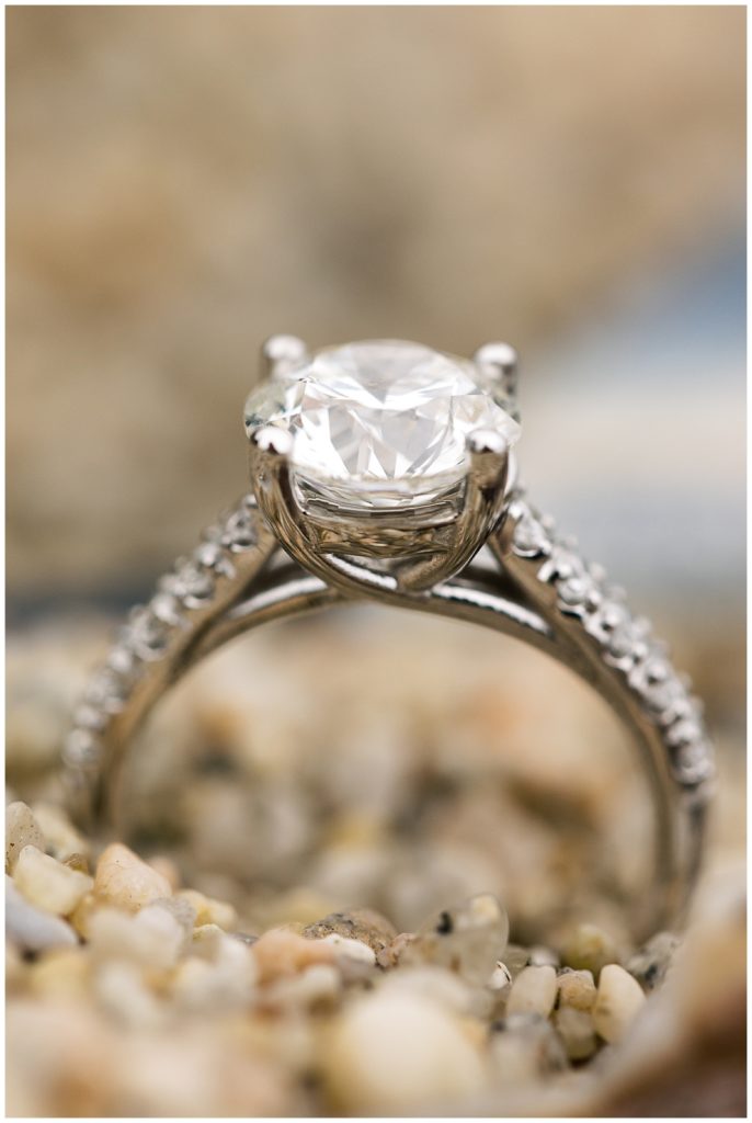 photograph of engagement ring in the sand
