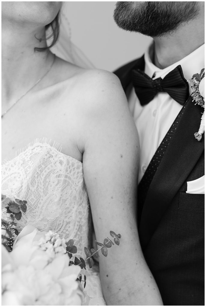 black and white wedding portrait photograph of the bride and groom from the chins down