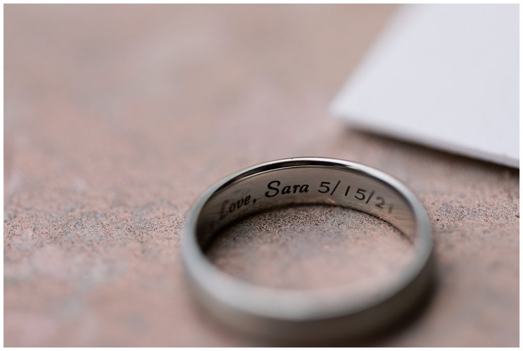 private Hollister wedding ring whose inner band reads "Love, Sara 5/15/21"