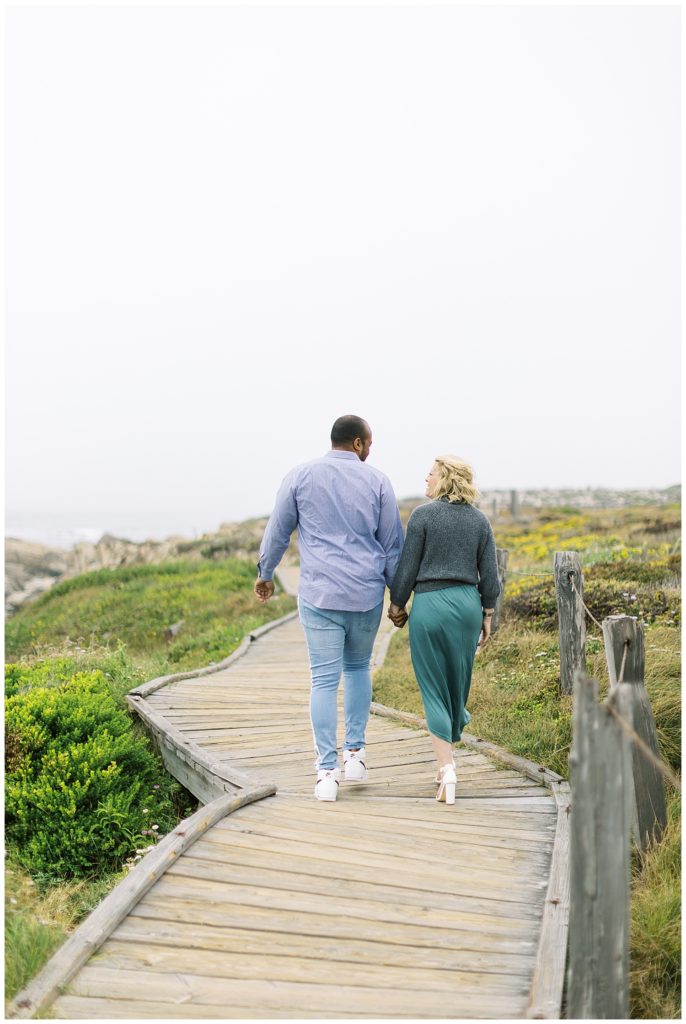 couple walking hand in hand away from the camera