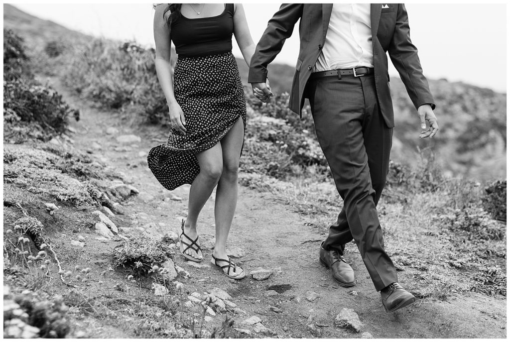 black and white photo of the couple from the shoulders down walking along a trail in Big Sur after their surprise proposal by Big Sur photographer AGS Photo Art