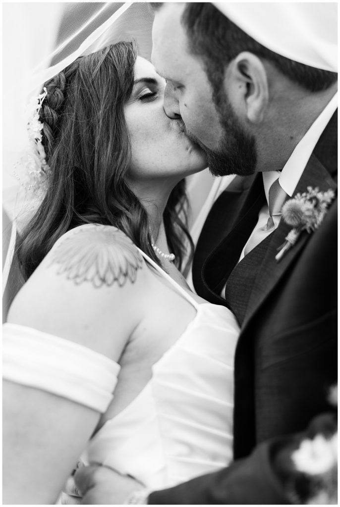 black and white Monterey wedding portrait of the couple sharing a kiss under the bride's veil at The Club At Pasadera by film photographer AGS Photo Art