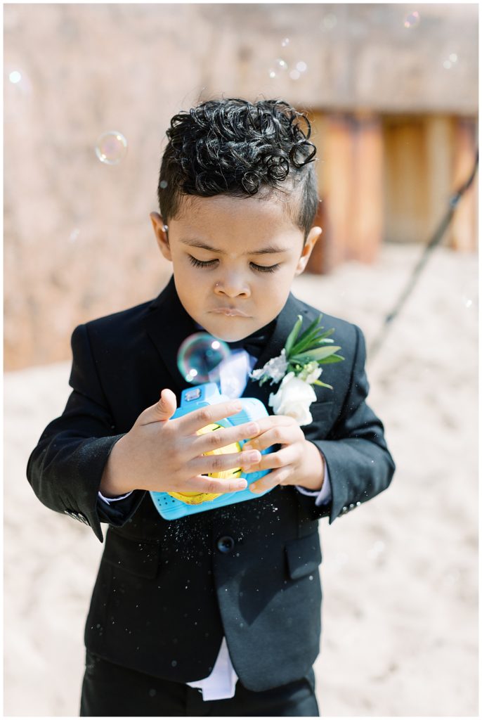 bride and groom's son playing with bubbles and a toy camera