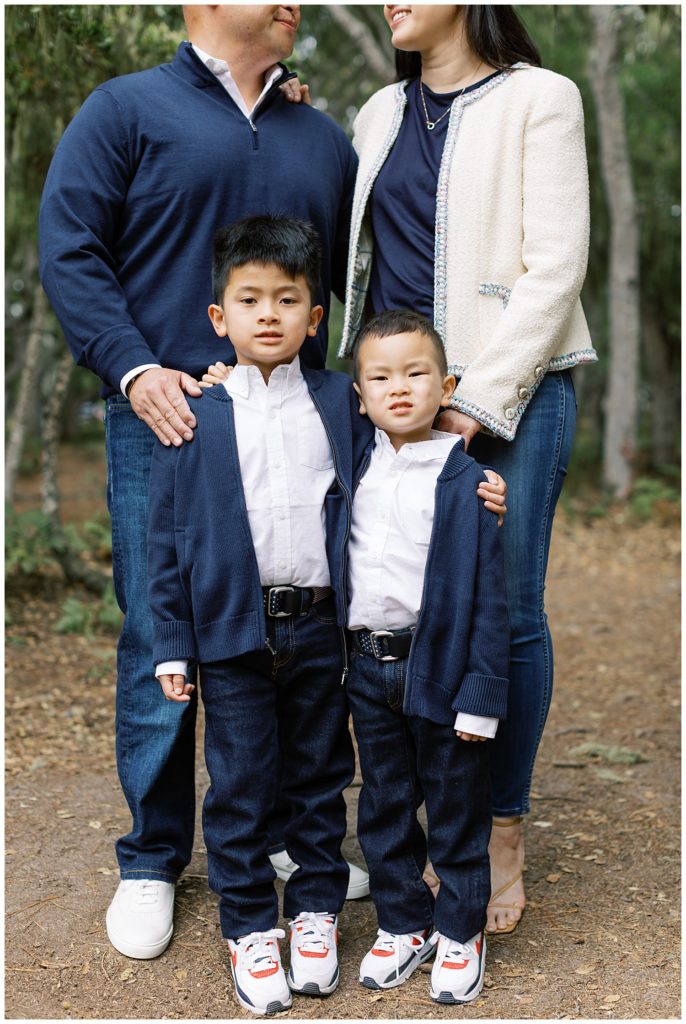 family session showing two boys in matching clue suits with their parents smiling at each other behind them