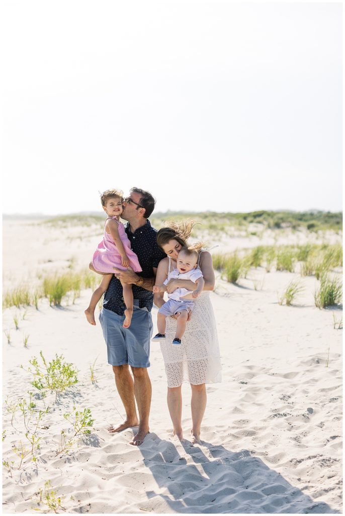 Cape May family session portrait of parents kissing their babies on their cheeks