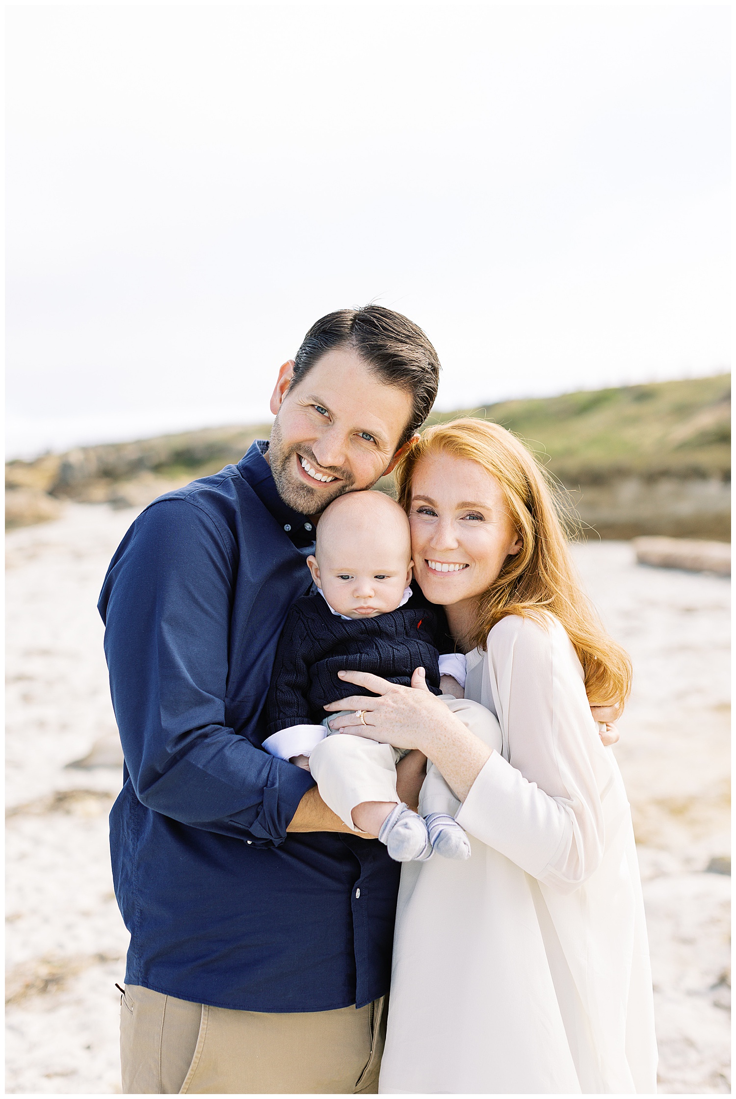 portrait of Mom and Dad with their newborn smiling at the camera during their family session in Pebble Beach by film photographer AGS Photo Art