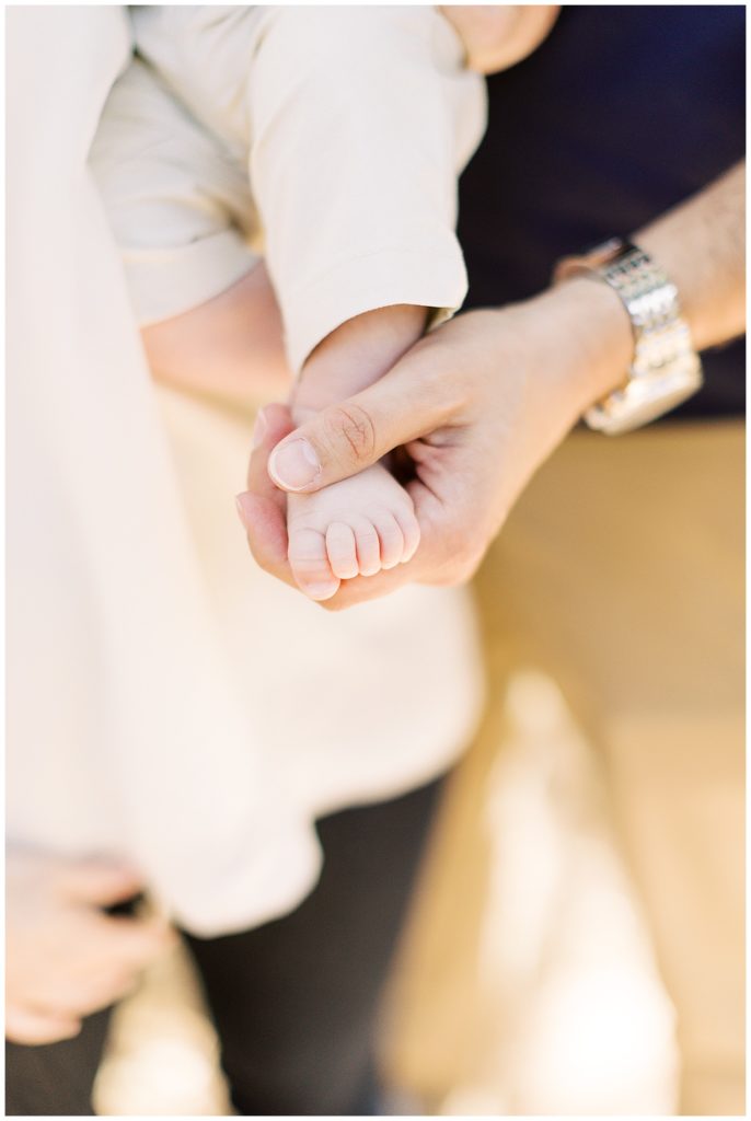 newborn baby's foot held in Dad's hand