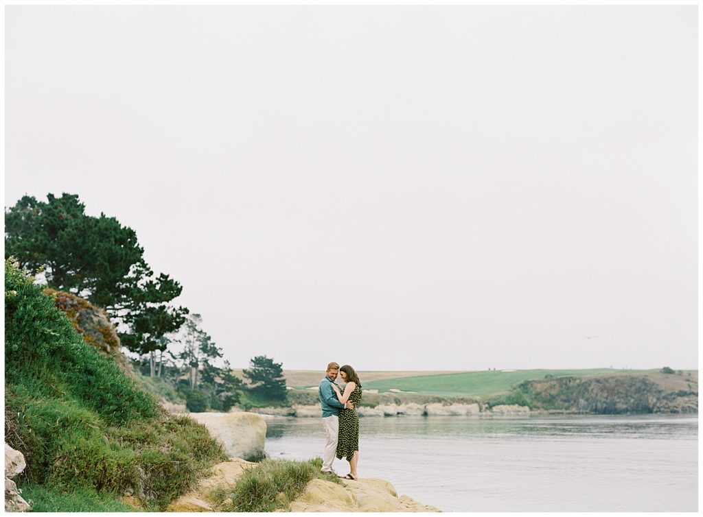 landscape photo of couple on the edge of the water for their Surprise Proposal In Pebble Beach by film photographer AGS Photo Art