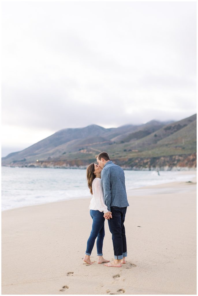 portrait of couple sharing a kiss at the beach for their engagement session in Big Sur