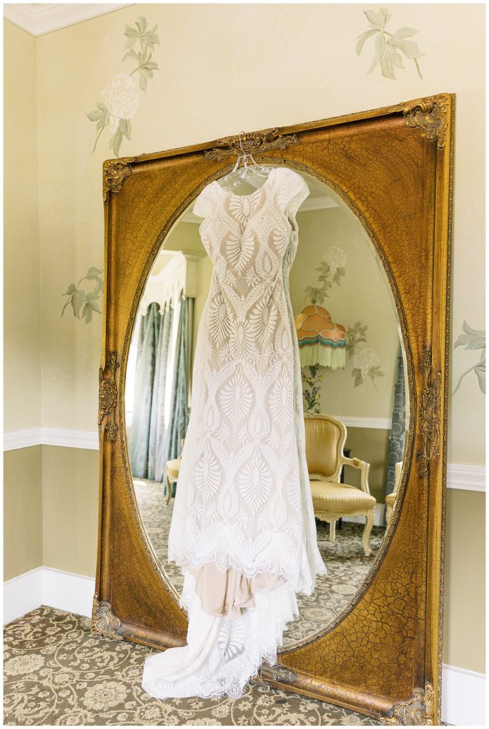 Monterey wedding gown by BHLDN hanging on a vintage mirror at The Perry House