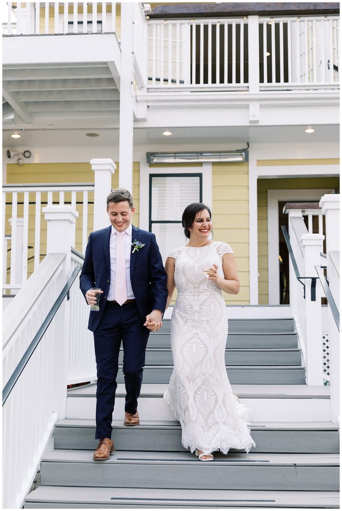couple walking hand-in-hand down the steps of The Perry House with champagne